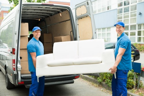 Professional movers loading desks and IT items for an office move