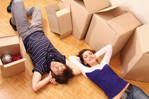 Packed boxes and furniture ready for collection by a van in Brentcross