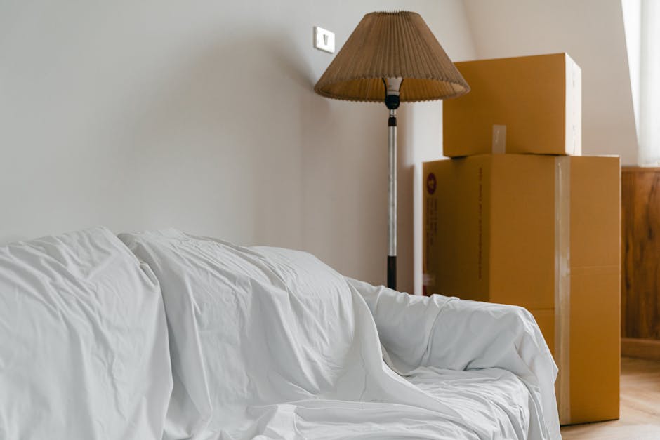 Inside the back of a van used by Man and Van Brent Cross during a home relocation, several stacked cardboard boxes of various sizes are visible, with some open and showing packing materials such as br