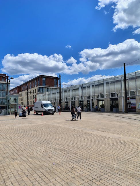 The image depicts a busy residential street in Brent Cross during daytime, with a variety of parked vehicles lining both sides of the road, including compact cars, sedans, and vans. In the foreground,