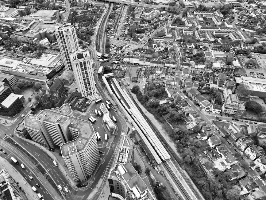 Aerial black-and-white photograph of an urban area near Brent Cross, showing multiple high-rise office buildings, commercial structures, and dense residential housing. The scene includes a network of